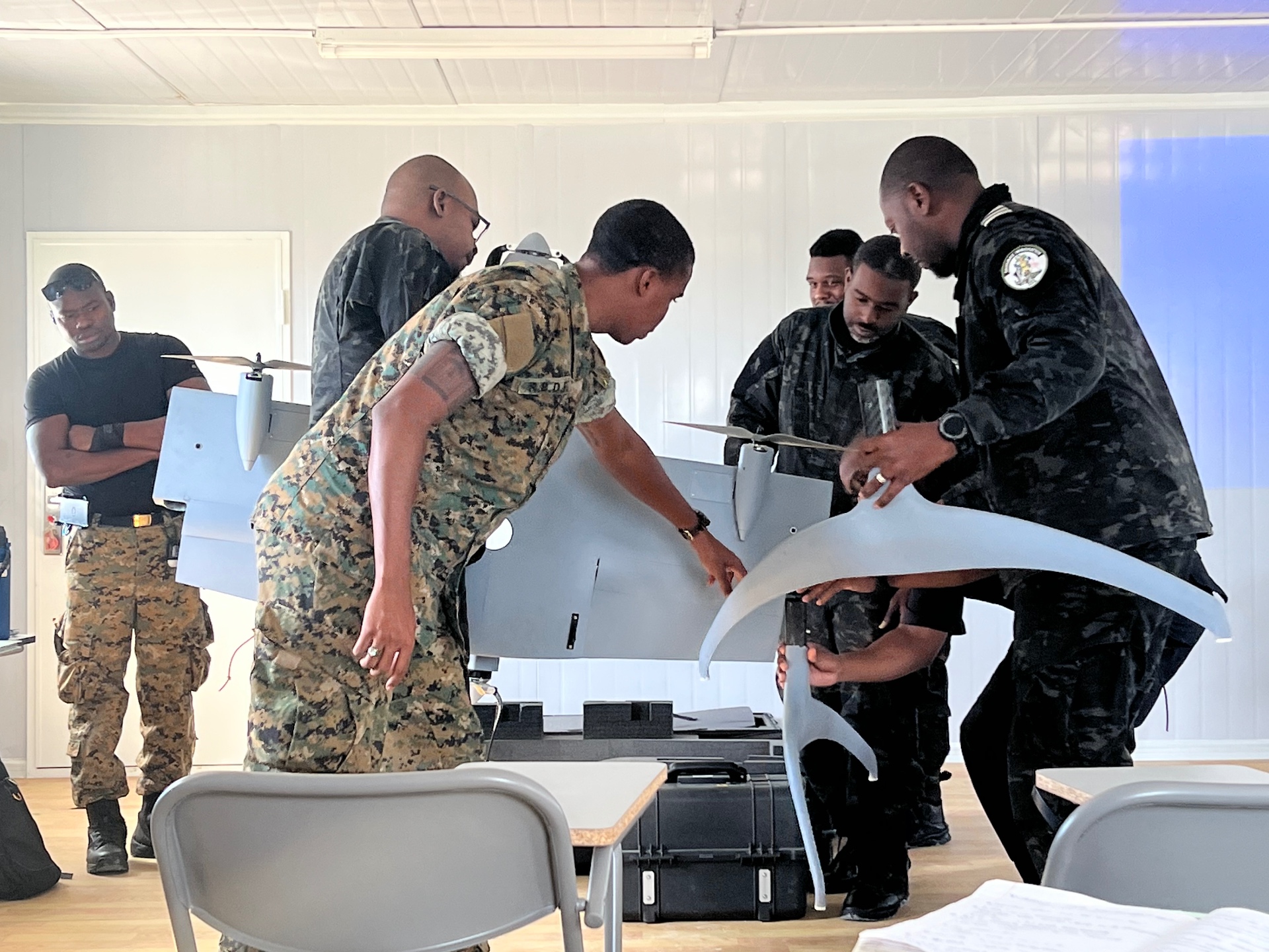 Trainees assembling a fixed-wing unmanned aircraft together in a training room
