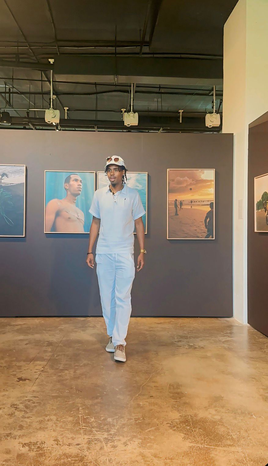 Andrick Wright walking through a photography exhibition in a gallery