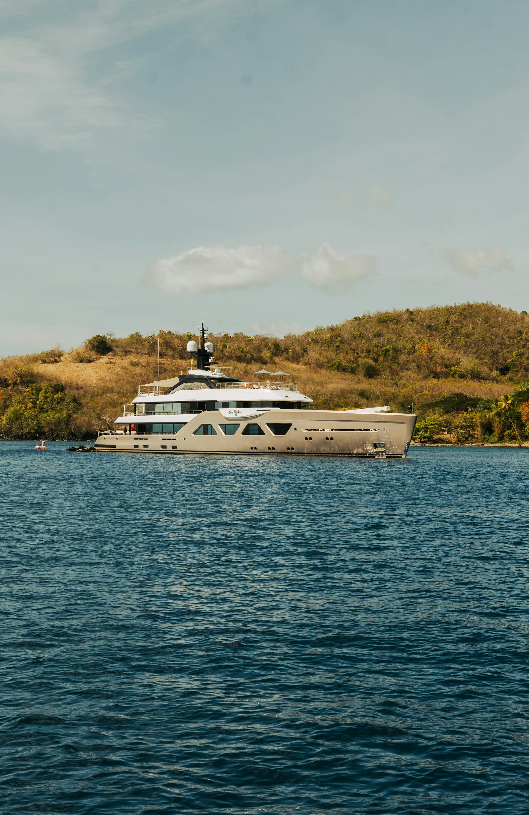 Luxury motor yacht anchored beside an island — stock photograph
