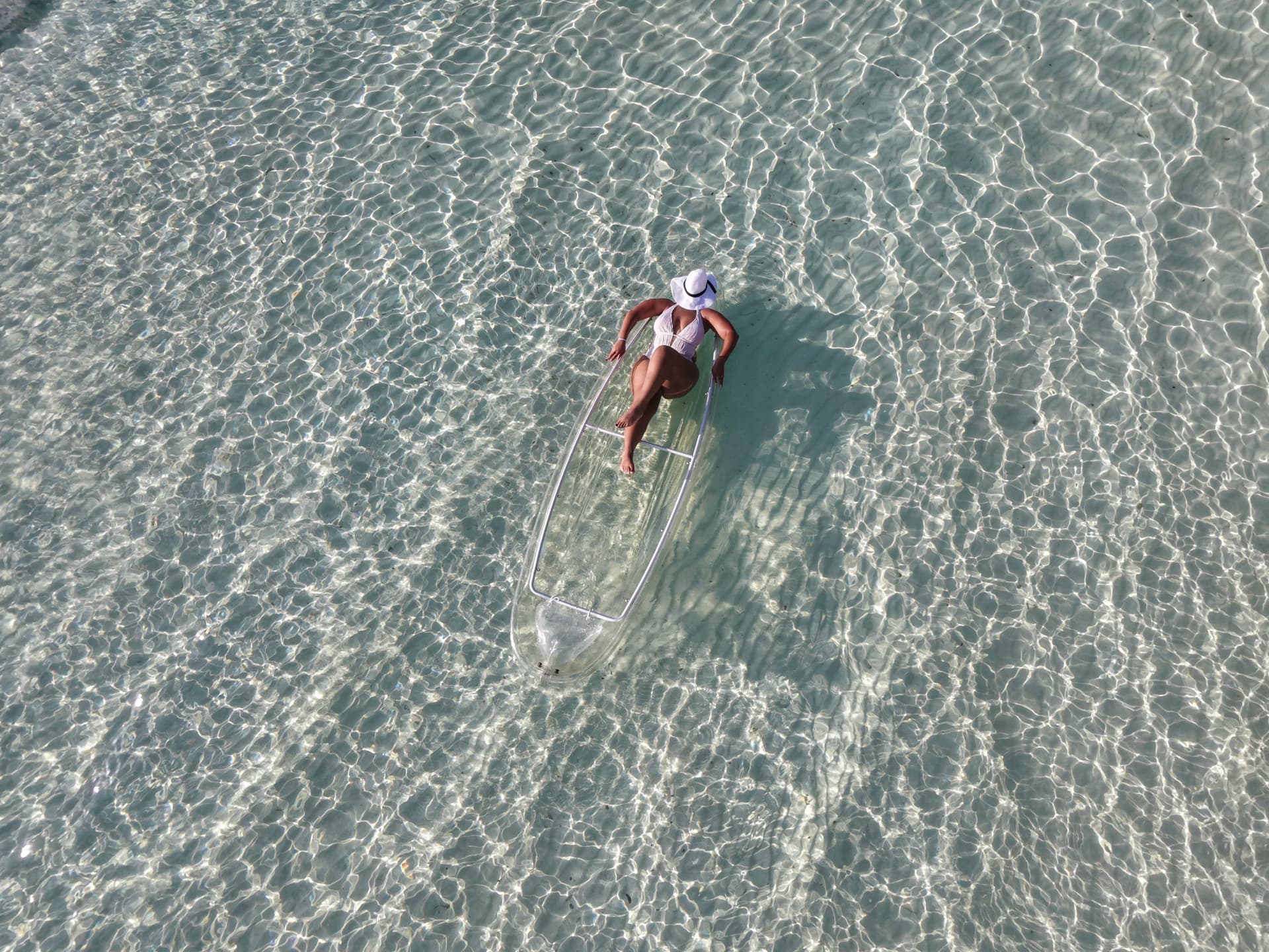 Overhead view of a clear kayak in rippling shallow water