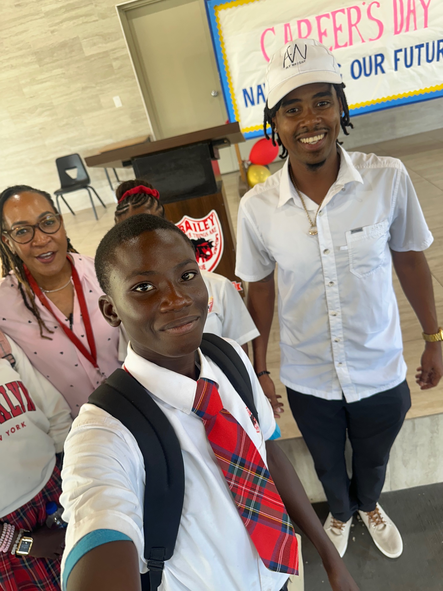 Andrick Wright taking a selfie with a smiling student at a school Career Day